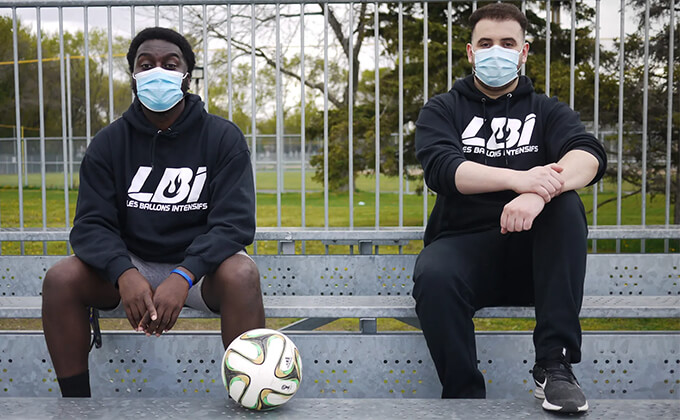Soccor players sitting wearing Les Ballons Intensifs hoodies