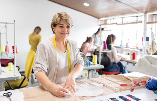 Transforming Fashion - a woman worker poses while making a garment